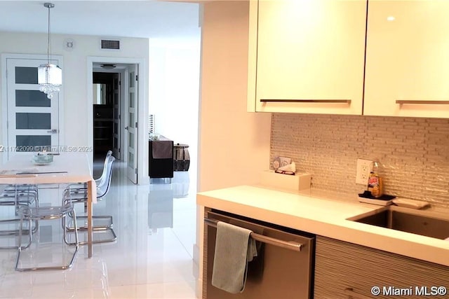 kitchen with tasteful backsplash, dishwasher, sink, and decorative light fixtures