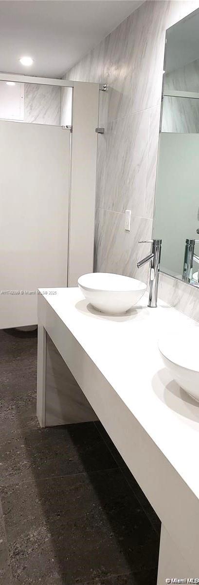 bathroom featuring vanity and tile walls