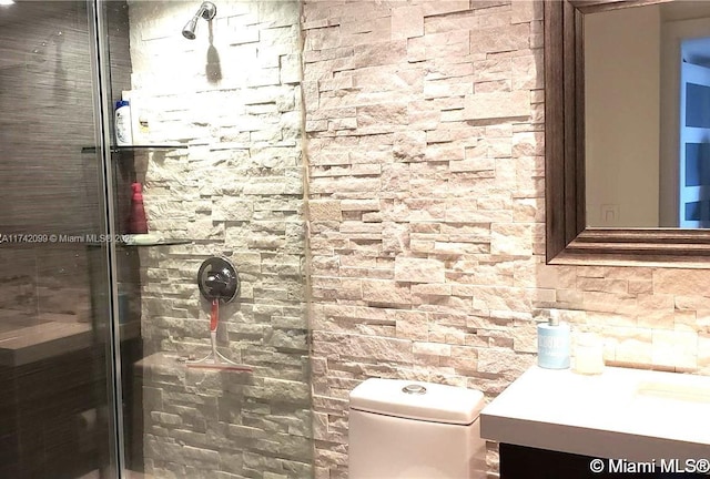 bathroom featuring vanity, toilet, and a tile shower