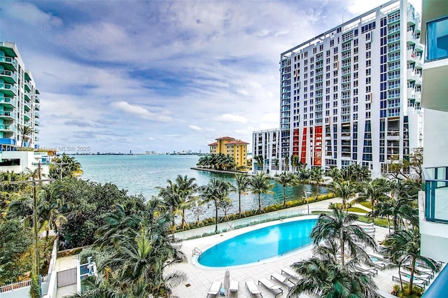 view of swimming pool with a water view and a patio area