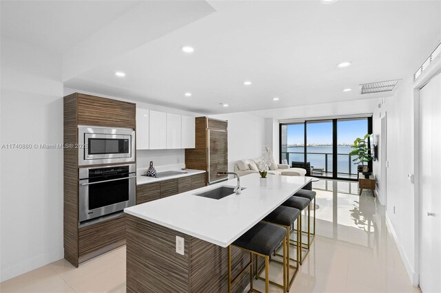 460 NE 28th St Unit 1404, Miami, FL 33137 - kitchen featuring stainless steel appliances, a sink, modern cabinets, a breakfast bar, and a water view