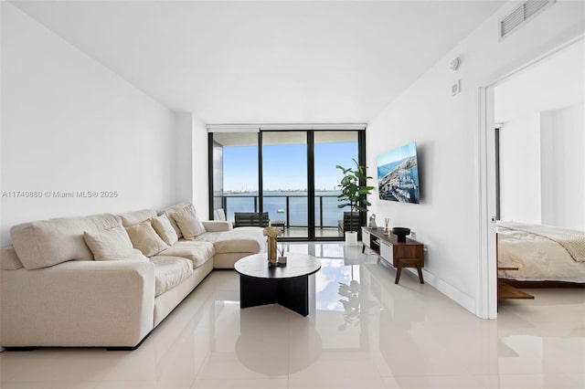 living room featuring expansive windows and light tile patterned flooring