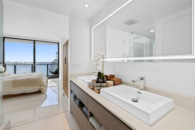 bathroom with a water view, vanity, and tile patterned flooring