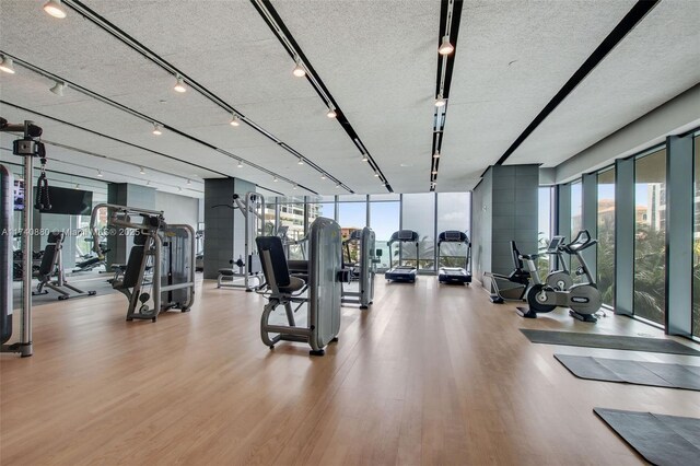 460 NE 28th St Unit 1404, Miami, FL 33137 - exercise room featuring wood finished floors, a wall of windows, and a textured ceiling