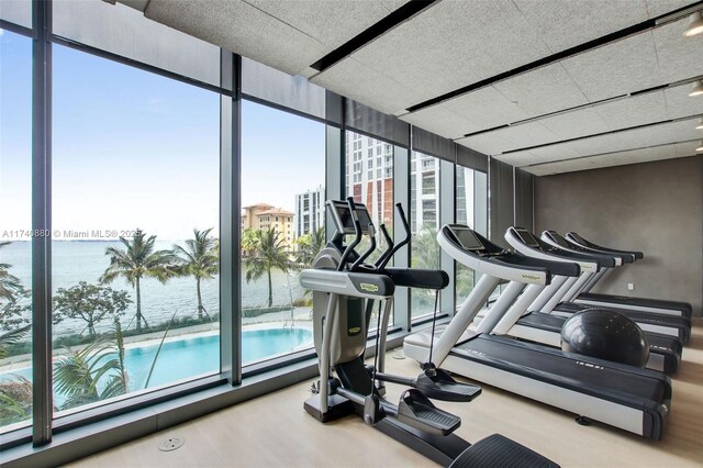 460 NE 28th St Unit 1404, Miami, FL 33137 - gym featuring floor to ceiling windows, a water view, and wood finished floors