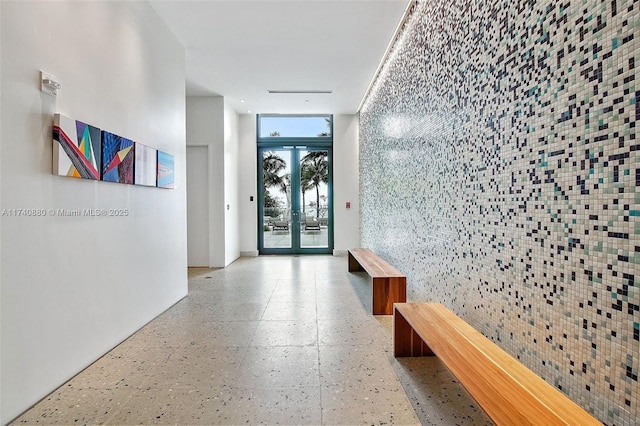 hallway featuring french doors and a wall of windows