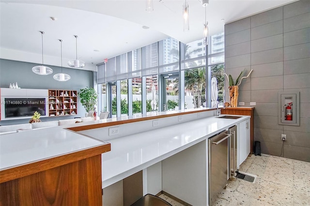 kitchen with sink, pendant lighting, and tile walls