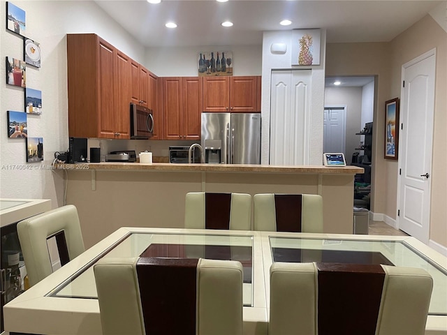 kitchen featuring a kitchen breakfast bar, kitchen peninsula, and appliances with stainless steel finishes