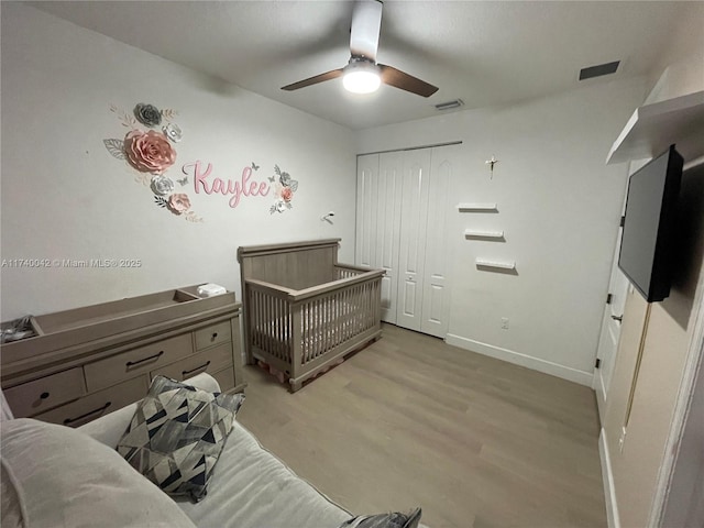 bedroom with ceiling fan, light hardwood / wood-style floors, and a closet