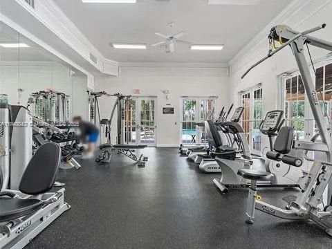 workout area featuring crown molding, french doors, and ceiling fan