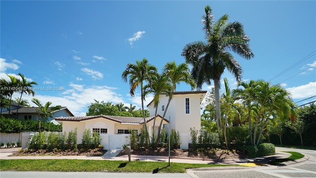 691 Ridgewood Rd, Key Biscayne, FL 33149 - mediterranean / spanish-style house with a tile roof, a fenced front yard, a gate, and stucco siding