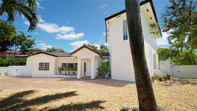 691 Ridgewood Rd, Key Biscayne, FL 33149 - mediterranean / spanish home with a tiled roof, fence, a gate, and stucco siding