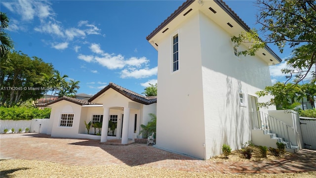 691 Ridgewood Rd, Key Biscayne, FL 33149 - rear view of house featuring fence, stucco siding, and a tile roof