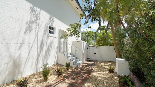 691 Ridgewood Rd, Key Biscayne, FL 33149 - view of home's exterior with a gate, stucco siding, stairway, and fence