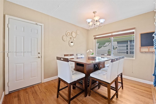 dining space featuring an inviting chandelier and light hardwood / wood-style floors