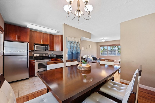 dining space with a chandelier and light hardwood / wood-style flooring