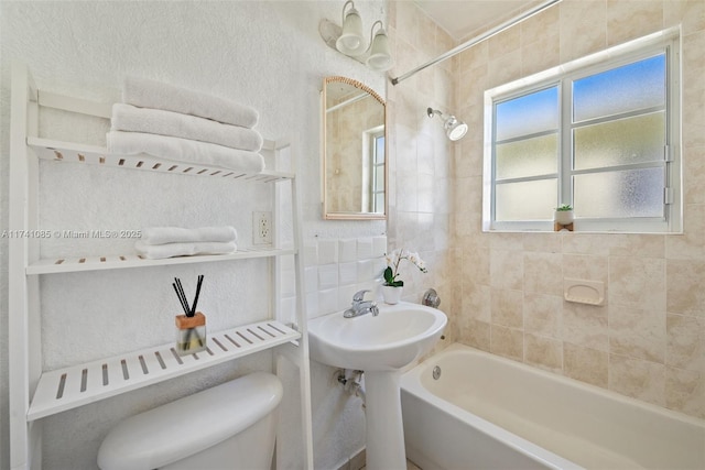 bathroom featuring toilet and tiled shower / bath combo