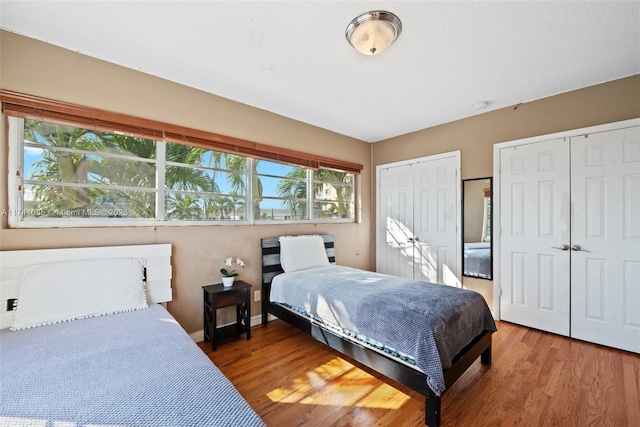 bedroom featuring multiple closets and hardwood / wood-style flooring