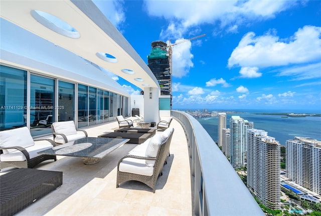 view of patio / terrace with a balcony and a water view