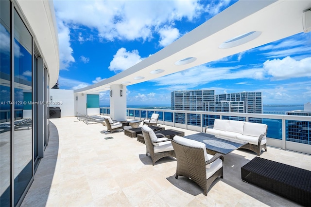 view of patio / terrace featuring an outdoor hangout area, a balcony, and a water view