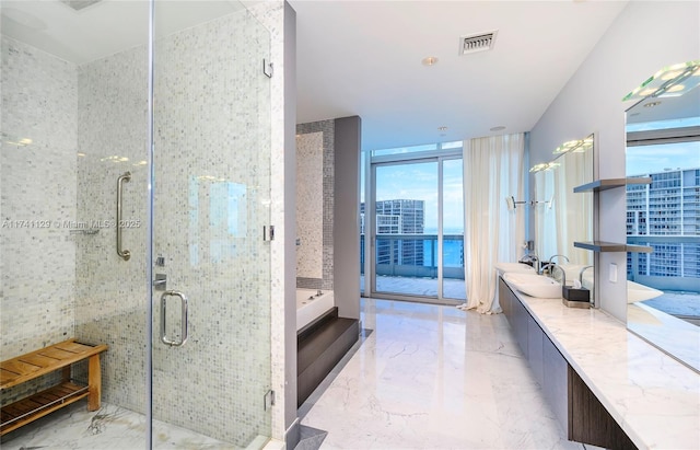 bathroom featuring vanity, a wall of windows, and separate shower and tub