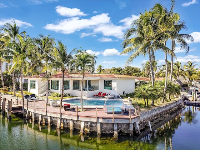 12905 Cherry Rd, North Miami, FL 33181 - back of house with a water view, an outdoor pool, stucco siding, a tile roof, and a patio area