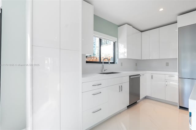 kitchen featuring modern cabinets, stainless steel appliances, and a sink