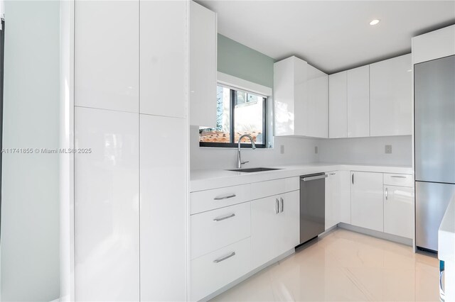 kitchen featuring a sink, light countertops, modern cabinets, and appliances with stainless steel finishes