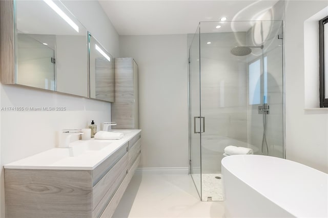 bathroom featuring a freestanding tub, baseboards, vanity, and a shower stall