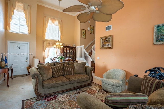 living room featuring stairway, visible vents, a towering ceiling, crown molding, and tile patterned floors