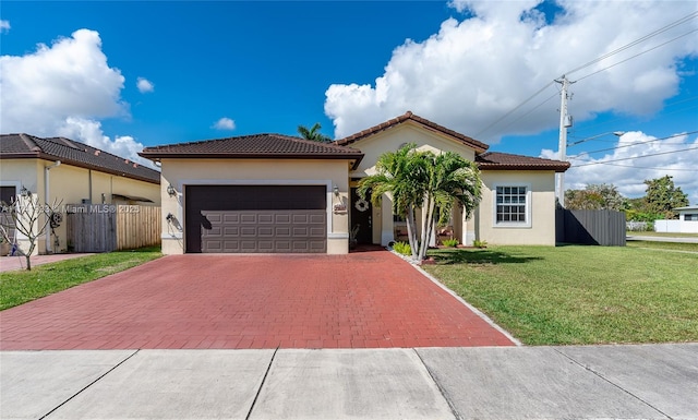 mediterranean / spanish-style house featuring a garage and a front yard