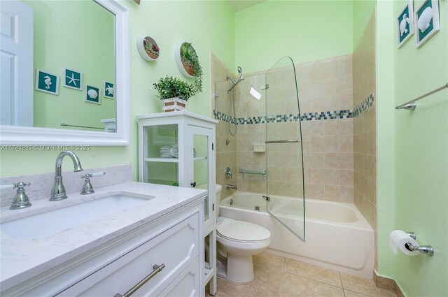 full bathroom featuring tiled shower / bath combo, vanity, tile patterned flooring, and toilet