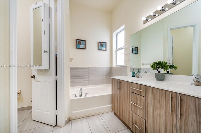 bathroom featuring tile patterned floors, vanity, and a tub