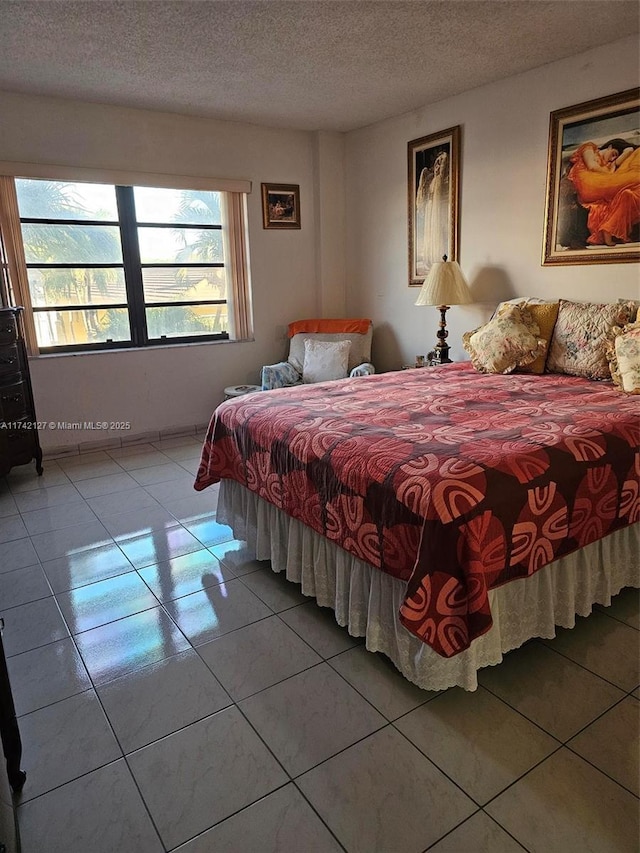 bedroom with light tile patterned floors and a textured ceiling