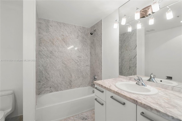 full bathroom with vanity, tiled shower / bath, and toilet