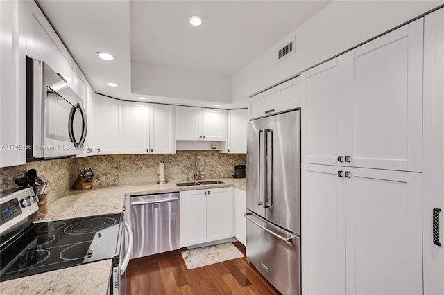 kitchen featuring white cabinetry, sink, stainless steel appliances, and light stone countertops