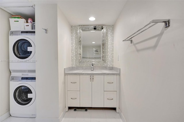 washroom with stacked washer and clothes dryer and sink