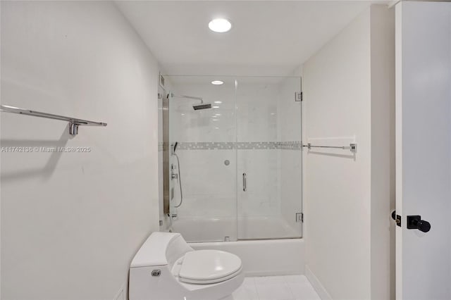 bathroom featuring toilet, tile patterned flooring, and combined bath / shower with glass door