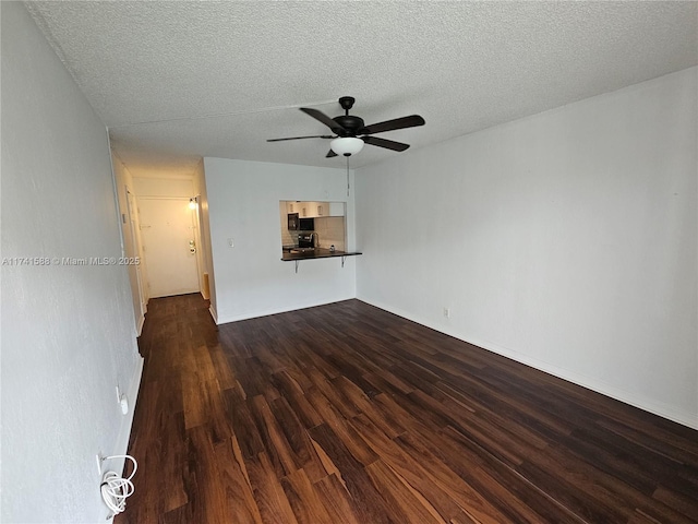 unfurnished living room with dark hardwood / wood-style flooring, a textured ceiling, and ceiling fan