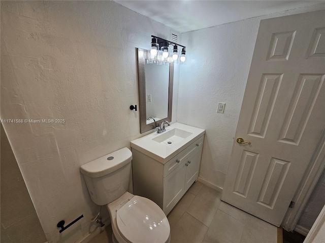 bathroom featuring tile patterned floors, vanity, and toilet