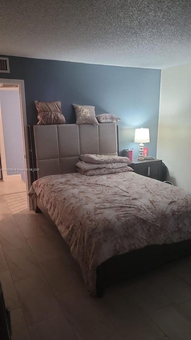 bedroom with wood-type flooring and a textured ceiling