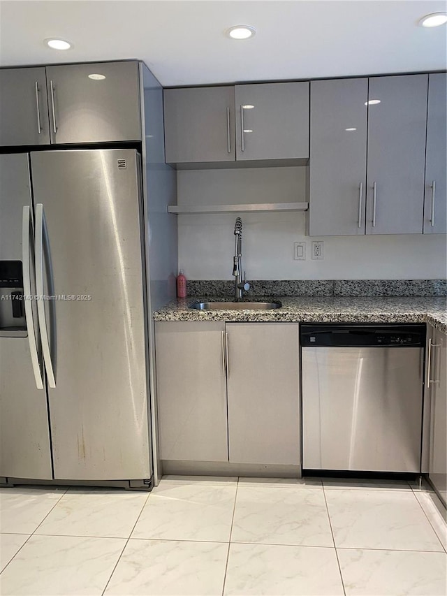 kitchen featuring stainless steel appliances, sink, dark stone countertops, and gray cabinets