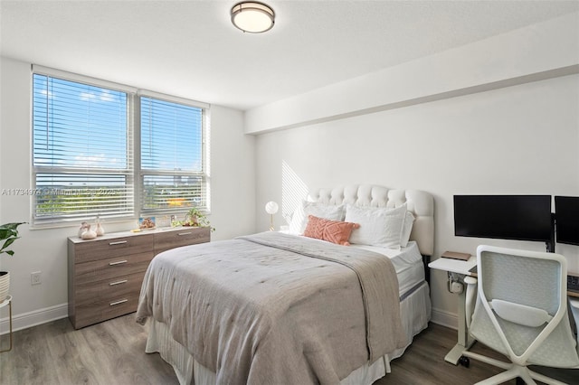 bedroom featuring baseboards and wood finished floors