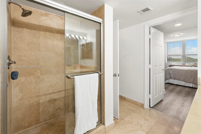 ensuite bathroom with a shower stall, visible vents, baseboards, and ensuite bathroom