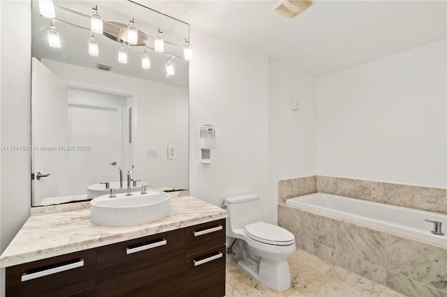 bathroom with vanity, toilet, and tiled tub