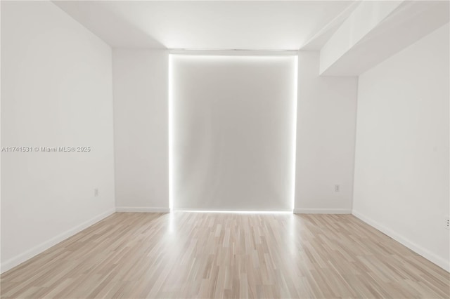 unfurnished room with light wood-type flooring