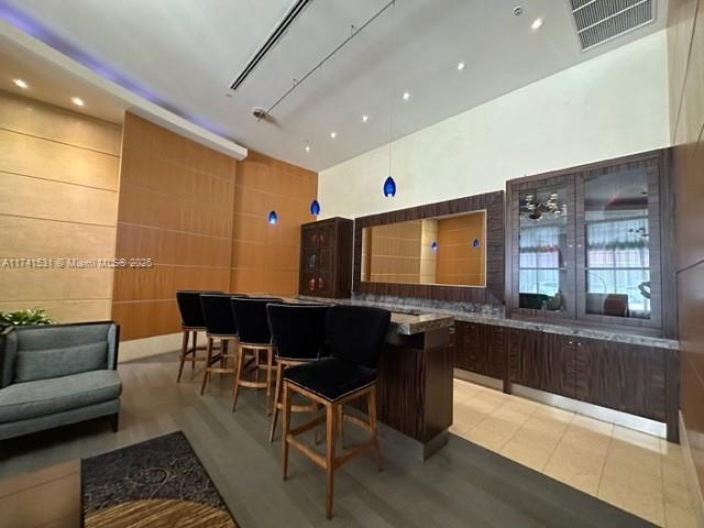 bar featuring dark brown cabinets and a high ceiling