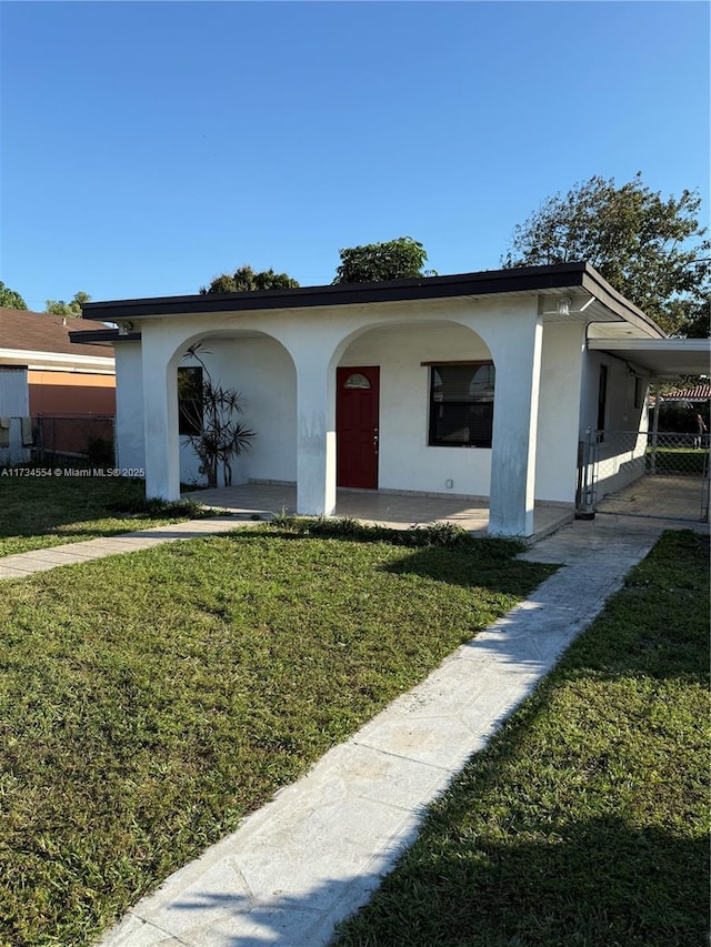 view of front of property featuring a front lawn and a carport