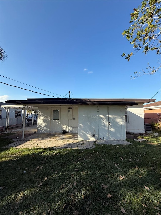 rear view of property featuring a lawn and a patio