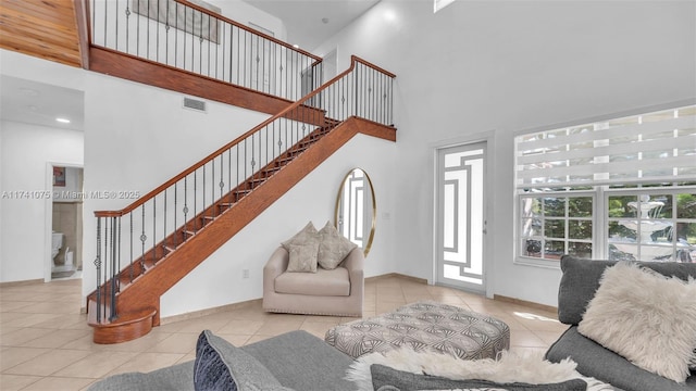 living room with a high ceiling and light tile patterned flooring